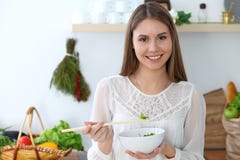 烹调在厨房里的年轻愉快的妇女 健康膳食、生活方式和烹饪概念 早晨好从新鲜开始 免版税图库摄影 烹调在厨房里的年轻愉快的妇女 健康膳食、生活方式和烹饪概念 早晨好从新鲜开始 免版税图库摄影