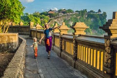 爸爸和儿子旅客在普拉Luhur Uluwatu寺庙,巴厘岛,印度尼西亚 惊人的风景-与蓝天和海的峭壁 旅行的wi 免版税库存照片 爸爸和儿子旅客在普拉Luhur Uluwatu寺庙,巴厘岛,印度尼西亚 惊人的风景-与蓝天和海的峭壁 旅行的wi 免版税库存照片