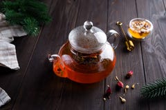玻璃茶壶用新近地酿造的清凉茶和蜂蜜在木背景 温暖的圣诞节或热的冬天饮料 图库摄影 玻璃茶壶用新近地酿造的清凉茶和蜂蜜在木背景 温暖的圣诞节或热的冬天饮料 图库摄影
