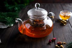玻璃茶壶用新近地酿造的清凉茶和蜂蜜在木背景 温暖的圣诞节或热的冬天饮料 库存图片 玻璃茶壶用新近地酿造的清凉茶和蜂蜜在木背景 温暖的圣诞节或热的冬天饮料 库存图片