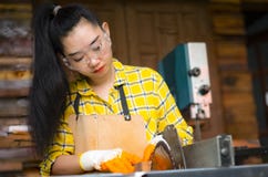 站立是运作被切开的木头的工艺在与圆锯的一个工作台的妇女电动工具在木匠机器 库存图片 站立是运作被切开的木头的工艺在与圆锯的一个工作台的妇女电动工具在木匠机器 库存图片