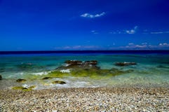 美丽如画的夏天海滩,在海浪的岩石在美丽的绿松石海排行 库存照片 美丽如画的夏天海滩,在海浪的岩石在美丽的绿松石海排行 库存照片