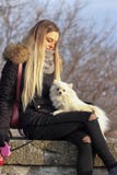 美丽的年轻微笑的女孩漫步与小白色狗 德国矮小的波美丝毛狗 pomeranian 库存图片 美丽的年轻微笑的女孩漫步与小白色狗 德国矮小的波美丝毛狗 pomeranian 库存图片