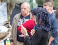 节日的参加者在中世纪夫人的服装的在镜子试穿一个链子并且注视着普珥节节日机智 库存图片 节日的参加者在中世纪夫人的服装的在镜子试穿一个链子并且注视着普珥节节日机智 库存图片