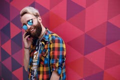 英俊的吸引人年轻人谈话在手机,在multicolore backgound 库存图片 英俊的吸引人年轻人谈话在手机,在multicolore backgound 库存图片