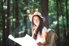 英俊的年轻旅客女孩举行定位图在手和看起来上定向方式旅行的与背包 免版税库存照片 英俊的年轻旅客女孩举行定位图在手和看起来上定向方式旅行的与背包 免版税库存照片