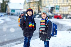 走到学校的基本的类的两个小孩男孩在降雪期间 获得乐趣和使用与的愉快的孩子 库存图片 走到学校的基本的类的两个小孩男孩在降雪期间 获得乐趣和使用与的愉快的孩子 库存图片