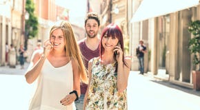 跟随俏丽的妇女的年轻人,当获得乐趣一起在城市街道-在每天生活方式时的技术概念上 库存图片 跟随俏丽的妇女的年轻人,当获得乐趣一起在城市街道-在每天生活方式时的技术概念上 库存图片