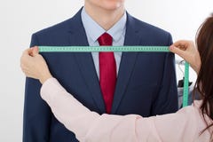 采取企业夹克衣服的裁缝的特写镜头图象测量 在红色领带的商人和在被隔绝的演播室的蓝色衣服 免版税库存照片 采取企业夹克衣服的裁缝的特写镜头图象测量 在红色领带的商人和在被隔绝的演播室的蓝色衣服 免版税库存照片