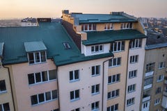 顶楼附录与塑料窗口、用绿色金属支持的板条盖的屋顶和墙壁的室外部鸟瞰图,新的天沟 免版税库存照片 顶楼附录与塑料窗口、用绿色金属支持的板条盖的屋顶和墙壁的室外部鸟瞰图,新的天沟 免版税库存照片