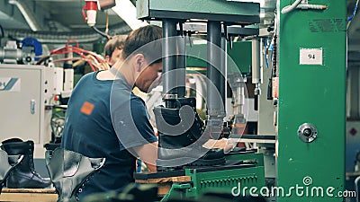 Μονάδα παραγωγής υποδημάτων Ο εργαζόμενος στο εργοστάσιο χρησιμοποιεί ένα  μηχάνημα για να βάλει ένα παπούτσι σε σχήμα φιλμ μικρού μήκους - Βίντεο από  workspace: 198208568