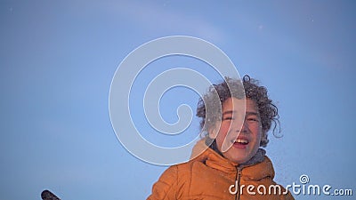 快乐的卷发的小学生投掷雪的画像 男孩戴一个救生服和黑色皮手套股票视频 视频包括有乐趣 愉快 快乐的卷发的小学生投掷雪的画像 男孩戴一个救生服和黑色皮手套股票视频 视频包括有乐趣 愉快