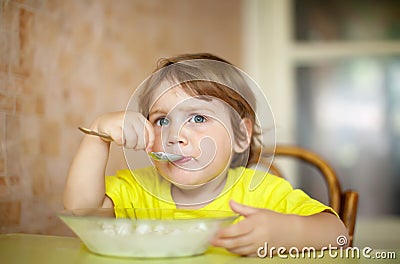 2 years child himself eats from plate Stock Photo