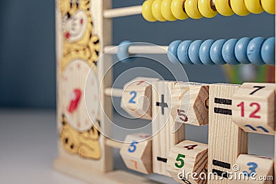 Children`s wooden game to learn the hours of a clock and simple math of addition, subtraction, multiplication and division, calle Stock Photo