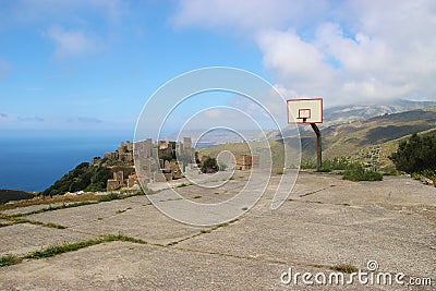 Abandoned Basketball court and hoop above the famous ruined town Vathia, Peloponnese, Greece. Stock Photo