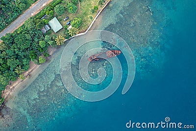 Abandoned broken sunken old ship that ran aground. Drone view. Tropical coast of Sanma, Vanuatu Stock Photo