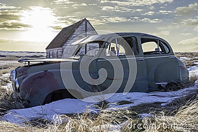 Abandoned car and church on a hillside overlooking twin grain elevators in Neidpath, SK Stock Photo