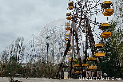 Abandoned carousel and abandoned ferris at an amusement park in the center of the city of Pripyat, the Chernobyl disaster, the exc Editorial Stock Photo