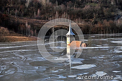 Abandoned church in a mud lake. Natural mining disaster Stock Photo