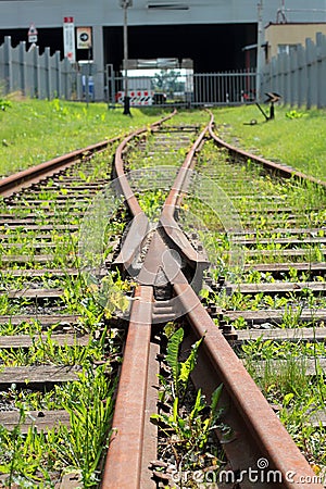 Abandoned converging railway tracks against a wall Stock Photo