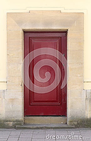 Abandoned dark red front door on the stone wall Stock Photo