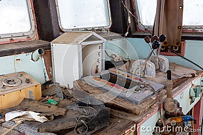 Abandoned and demolished cargo ship bridge inside view with throttle levers, communication devices and equipment Stock Photo