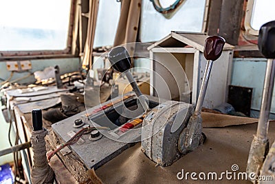 Abandoned and demolished cargo ship bridge inside view with throttle levers, communication devices and equipment Stock Photo