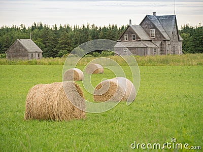 Abandoned farm house and bales of hay Stock Photo