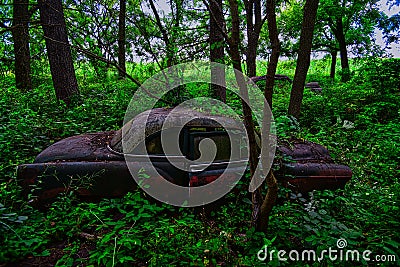 Abandoned farm and vintage cars decay in the woods on an abandoned property in Wisconsin Editorial Stock Photo