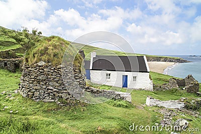 Abandoned farmhouse Great Blasket Island, Ireland. Farmhouse and round building from natural stone slabs with grass on roof. Stock Photo