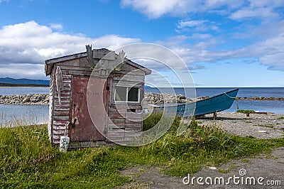 Abandoned Fishing Shack and Boat by the Shore in Newfoundland Stock Photo