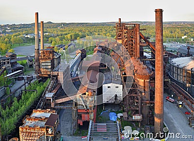 Abandoned ironworks factory with forest in the background Stock Photo