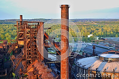 Abandoned ironworks factory - rusty chimney sunlit by the sun Stock Photo