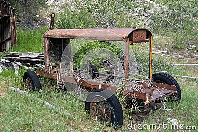 Abandoned mining vehicle cart in an overgrown field in Bayhorse Ghost Town in Idaho Stock Photo