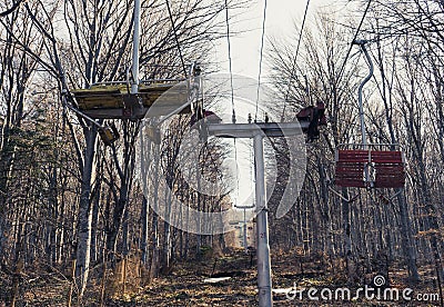 abandoned mountain Ski Lift in the forest with wood chairs Stock Photo