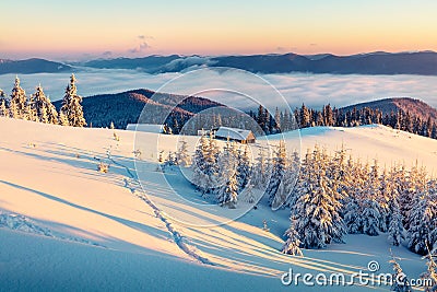 Abandoned mountain village in high mountains. Bright winter scene of Carpathians. Misty sunrise in mountain valley with snow cover Stock Photo