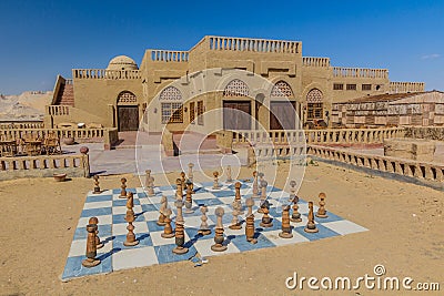 Abandoned mud brick hotel witch a chess board in Al Qasr village in Dakhla oasis, Egy Stock Photo