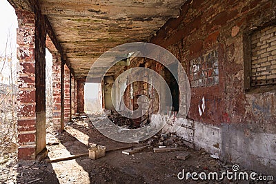 Abandoned old factory with brick columns and debris Stock Photo