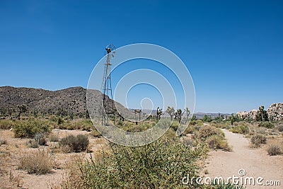 Abandoned old fashioned windmill sits along the trail to the Wall Street Mill in the desert Stock Photo