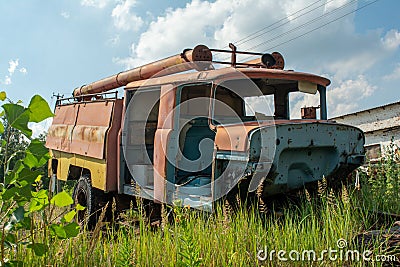 Abandoned old fire station truck during summer in the lost forgotten village Stock Photo