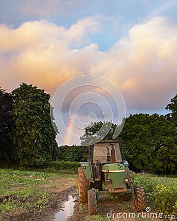 Abandoned Old tractor in farmerâ€™s field during beautiful Summer sunset in English countryside landscape Editorial Stock Photo