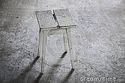 abandoned place with wooden stool on grey floor Stock Photo