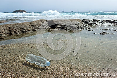 An abandoned plastic water bottle is lying on the beach. Stock Photo