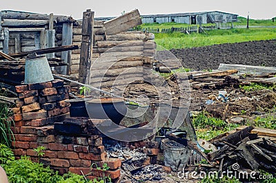 Abandoned ruined old house, hut. In the middle stands a stove. The fallen roof. Stock Photo