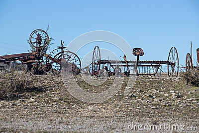 Abandoned, rusting vintage farm equipment in an open field Stock Photo