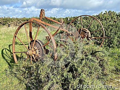 Abandoned rusty farm machinery on Pembrokeshire Coastal Path. Stock Photo