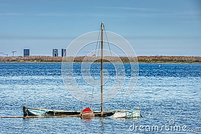 Abandoned sailing boat sunken in shallow water as nature claims back what once was hers conveys rejection and desertion feelings Stock Photo
