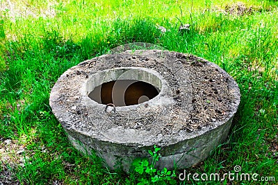 Abandoned sewer open dangerous hatch in the ground. Stock Photo