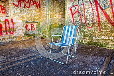 abandoned summer chair inside of an empty room decorated by various graphitti in gibraltar...IMAGE Stock Photo