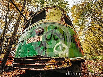 Abandoned Trolley Car in Woods in Fall with Caution Sign Stock Photo